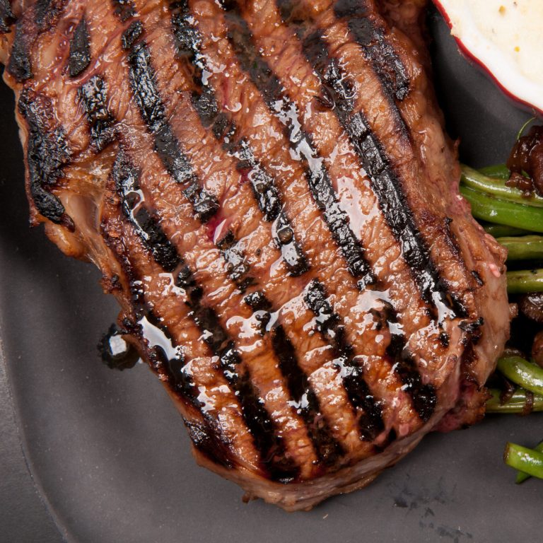 char grilled ribeye beef steak with cauliflower gratin and beans with mushrooms